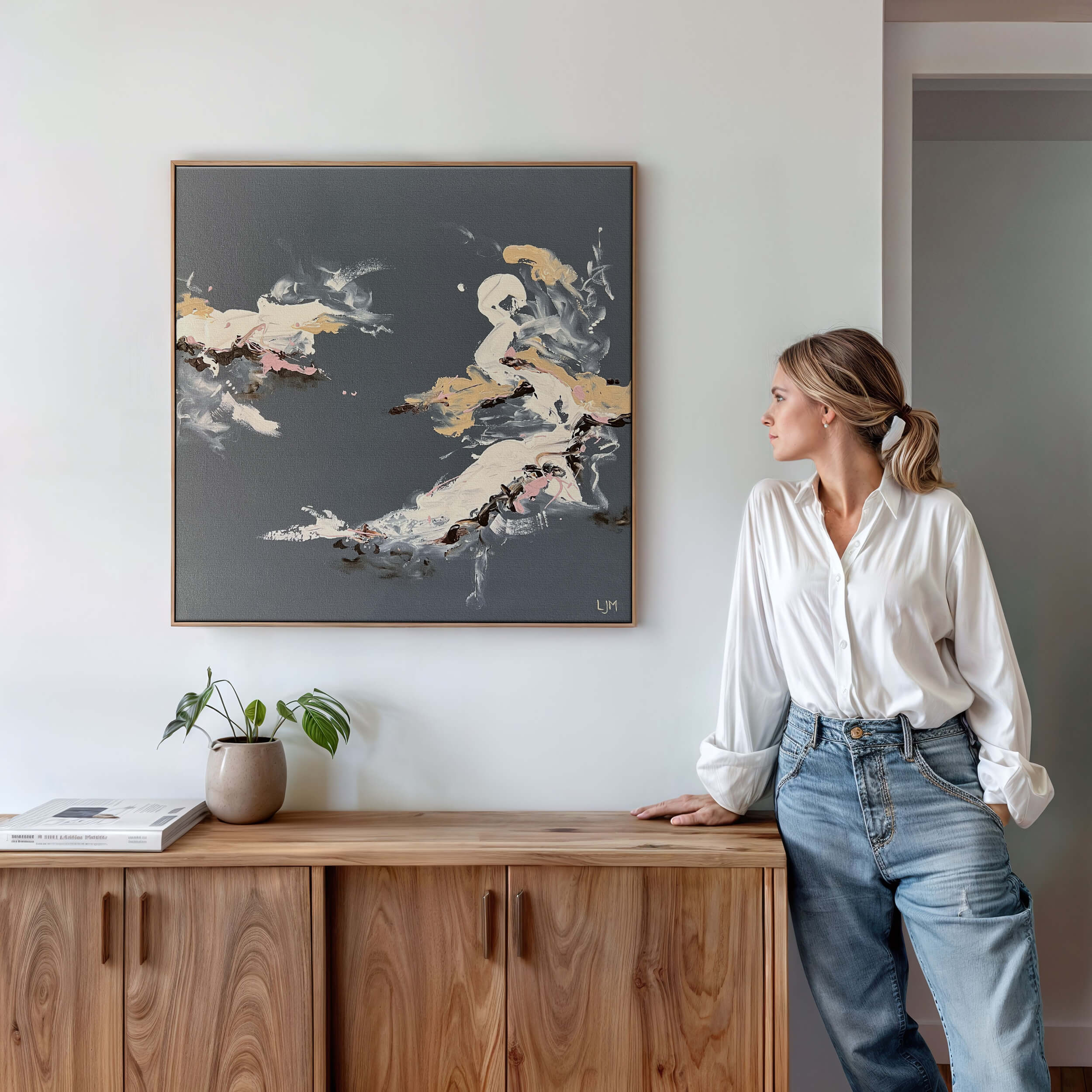 Woman staring at a medium grey abstract artwork by Lee J Morgan displayed on a room wall