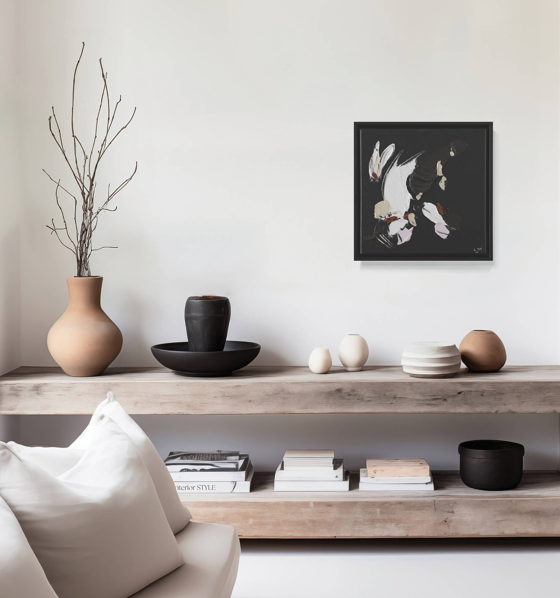 A small, black abstract painting by Lee J Morgan displayed on a living room wall